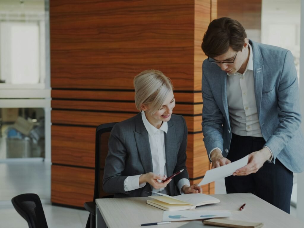 Two people going over documents at an office desk